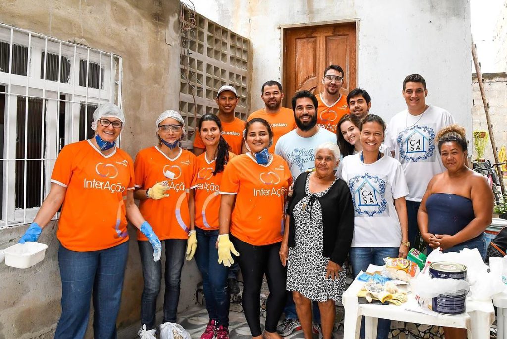 A dona de casa Carmosina Bispo e os colaboradores do projeto Adote uma Casa